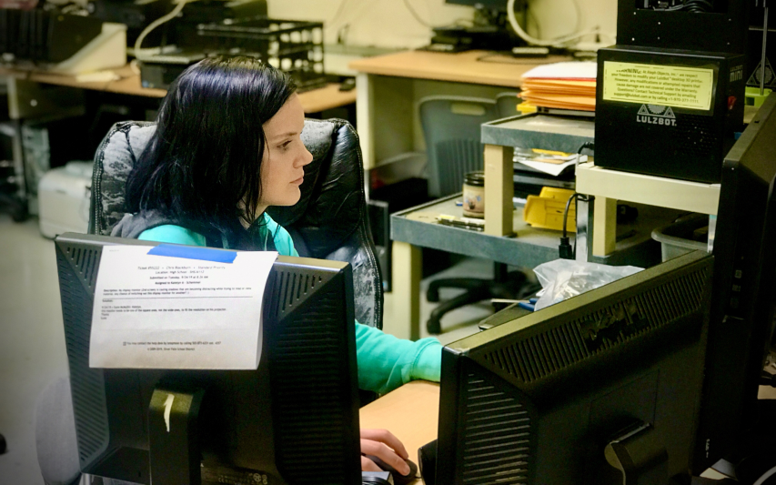 Ash Ayers examines IT help tickets. She is part of the team that services around 5,000 devices around the district.